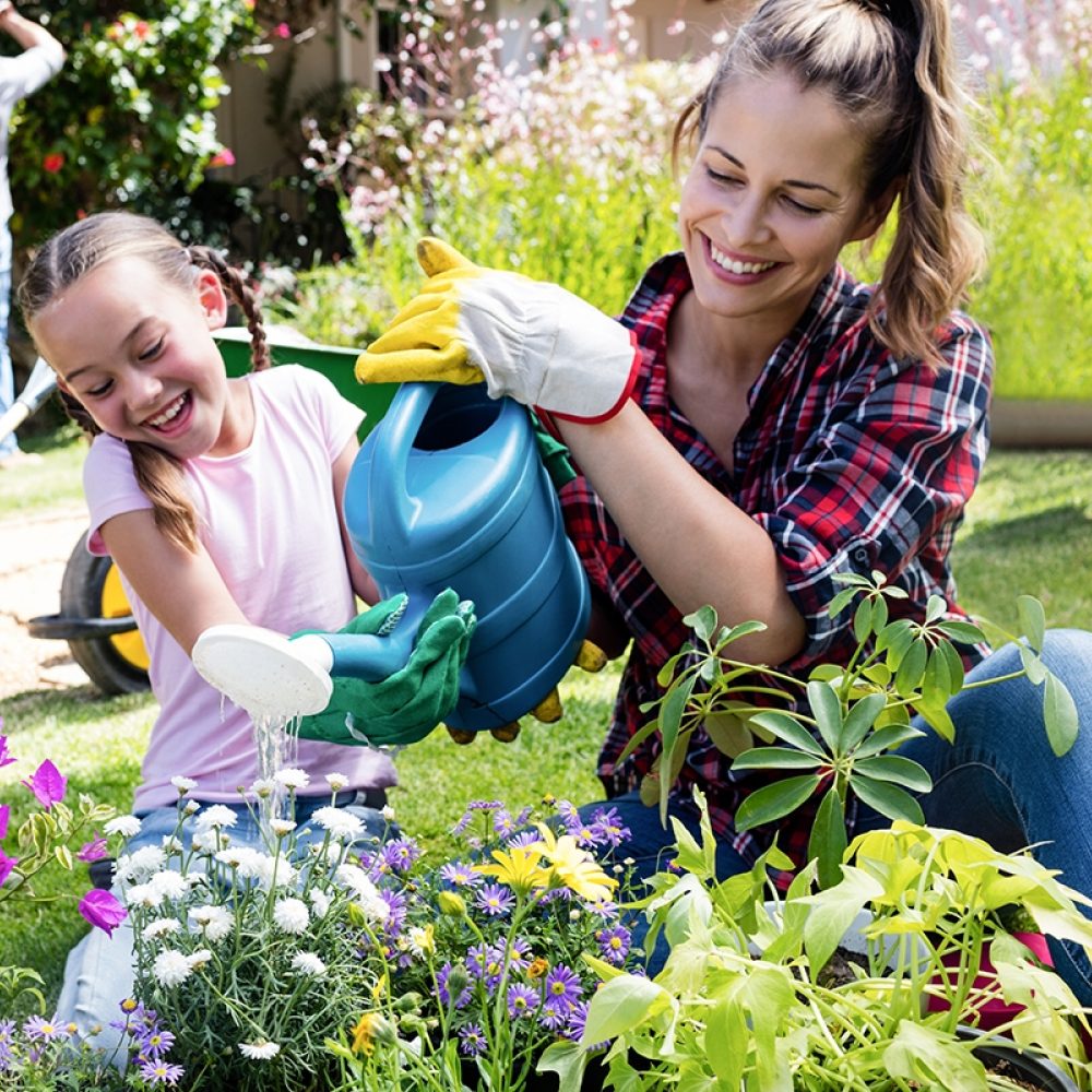 Mother and daughter watering plants